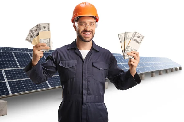Fabrikarbeiter Mit Schutzhelm Und Schutzbrille Und Geldstapeln Vor Solarzellen Auf — Stockfoto