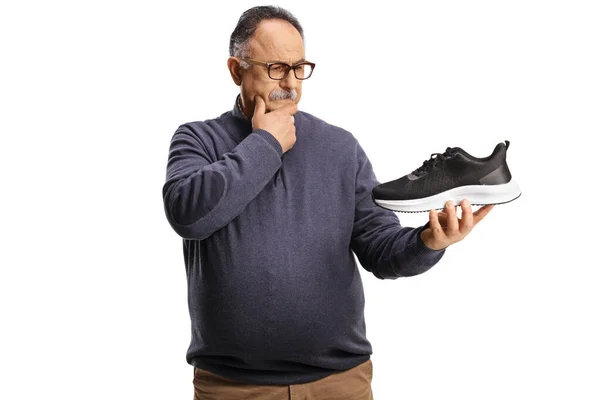 Doubtful Mature Man Holding Sneaker Isolated White Background — Stock Photo, Image