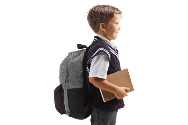 Üniformalı ve elinde beyaz arka planda izole bir kitap tutan bir çocuğun profil fotoğrafı.