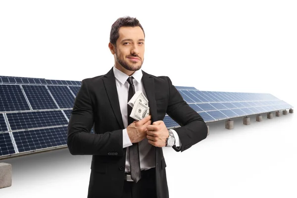 Empresário Colocando Dinheiro Bolso Terno Frente Uma Fazenda Solar Isolada — Fotografia de Stock