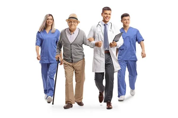 Group Healthcare Workers Walking Elderly Male Patient Isolated White Background — Stock Photo, Image