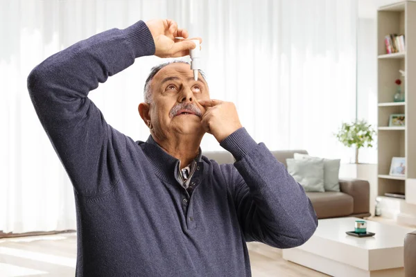 Starší Muž Pomocí Oční Kapky Doma Obývacím Pokoji — Stock fotografie
