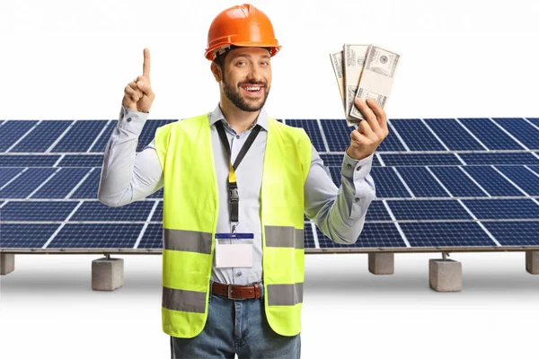 Μηχανικός Που Κρατάει Χρήματα Και Δείχνει Ένα Ηλιακό Αγρόκτημα Απομονωμένο — Φωτογραφία Αρχείου