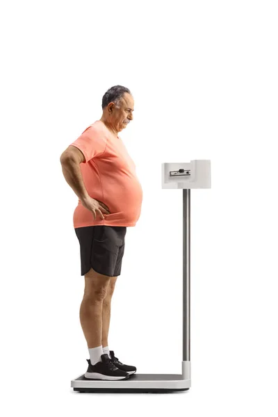 白い背景に隔離された体重計の上に立つ心配の成熟した男 — ストック写真