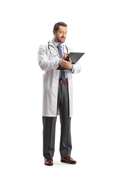 一个医生站在那里 用白色背景写下一份文件的全长照片 — 图库照片