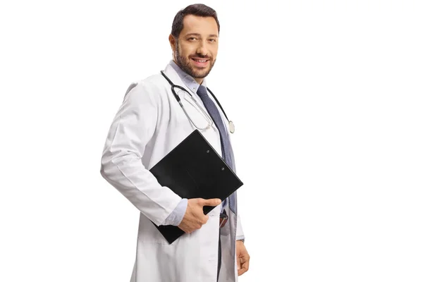 Junger Arzt Lächelt Und Hält Ein Klemmbrett Auf Weißem Hintergrund — Stockfoto