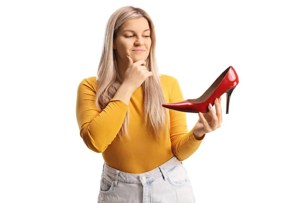 赤のハイヒールの靴を保持し 白い背景に隔離された考え若い女性 — ストック写真