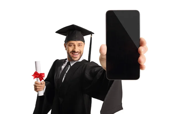 身着毕业礼服 拿着毕业文凭 手持智能手机 背景为白色的男人 — 图库照片