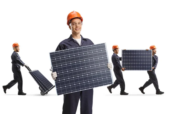 Pracownik Fabryki Trzymający Panel Słoneczny Inni Pracownicy Transportujący Panele Tyłu — Zdjęcie stockowe