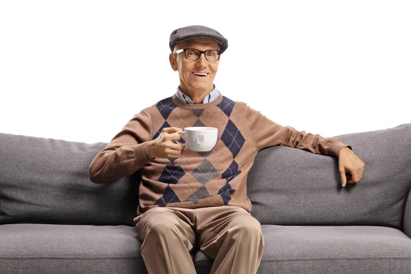 Anciano Sentado Sofá Con Una Taza Sonriendo Aislado Sobre Fondo — Foto de Stock