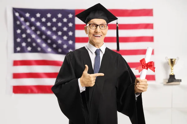 Hombre Mayor Con Vestido Graduación Con Diploma Señalando Frente Bandera — Foto de Stock