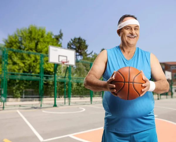 Reifer Mann Mit Stirnband Hält Einen Basketball Auf Einem Basketballplatz — Stockfoto