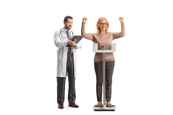 体重計の幸せな女性と白い背景に隔離された文書を書く男性医師 — ストック写真