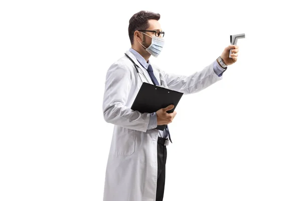 一名戴口罩的男医生手持白色背景的远红外温度计拍摄的个人资料 — 图库照片