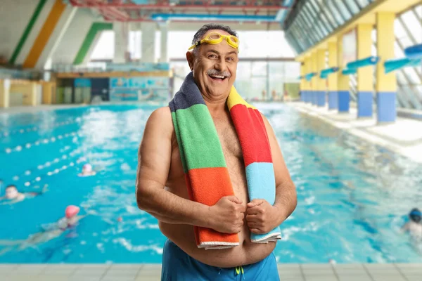 身穿泳衣 提着毛巾绕着脖子在游泳池边游泳的成熟男子 — 图库照片
