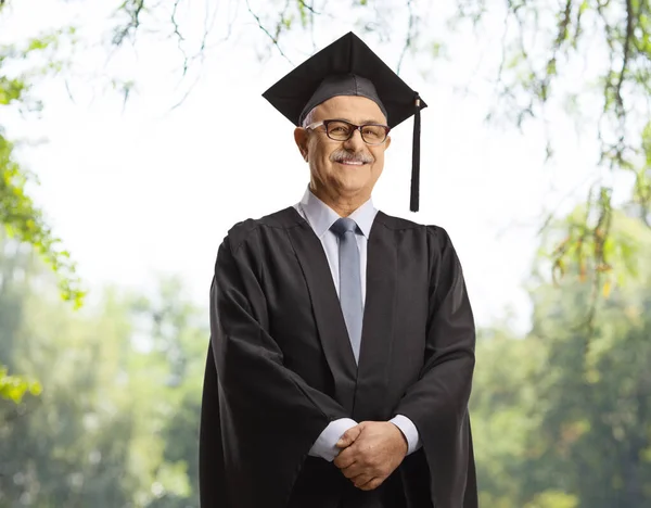 Universitätsdekan Schwarzem Abschlusskleid Und Posiert Freien Mit Bäumen Rücken — Stockfoto