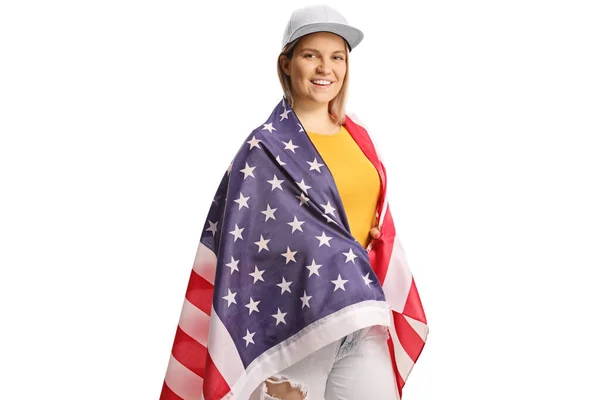 被白色背景隔离的年轻女性裹在美国国旗中 — 图库照片