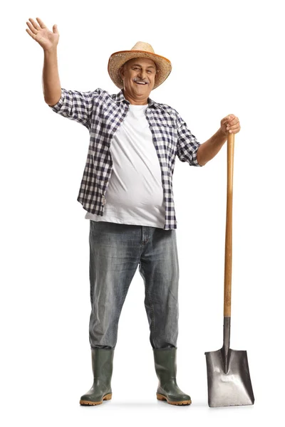 一个快乐的成熟农民的全长肖像 拿着铲子挥动着 面带微笑 背景是白色的 — 图库照片