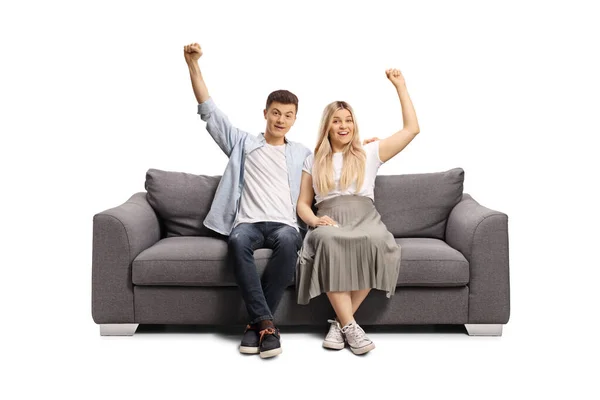 Cheerful Young Couple Sitting Sofa Raising Arms Isolated White Background — Stock Photo, Image