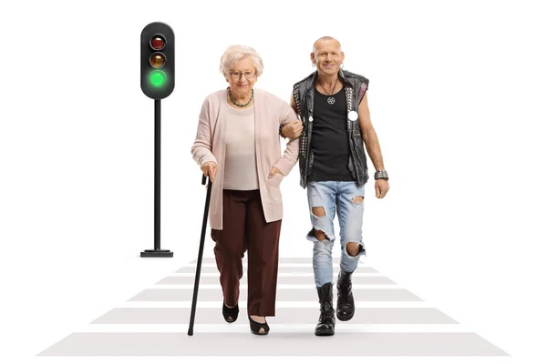 朋克男子用手杖帮助一位老年妇女穿过一条被白色背景隔离的街道 — 图库照片