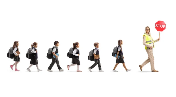 Beyaz Arka Planda Trafik Işaretli Bir Öğretmenin Arkasında Yürüyen Çocukların — Stok fotoğraf