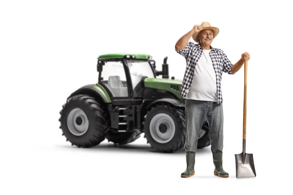 Зрелый Фермер Лопатой Стоящей Рядом Зеленым Трактором Приветствие Шляпе Изолированы — стоковое фото