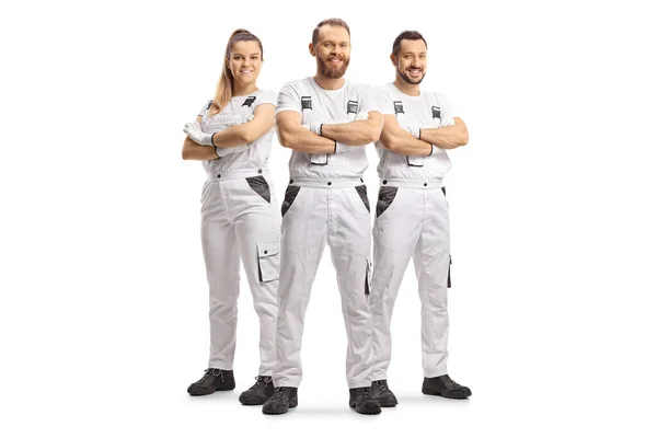 Team of house painters in white overall pants smiling at camera isolated on white background