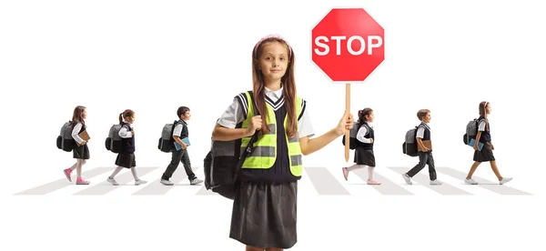 拿着停车交通标志的女学生和其他因白人背景而被隔离在后面的过马路的儿童 — 图库照片