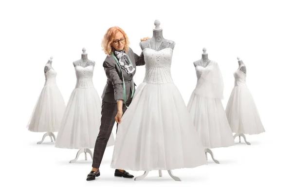 裁缝师用白色背景隔离的人偶测量婚纱尺寸 — 图库照片