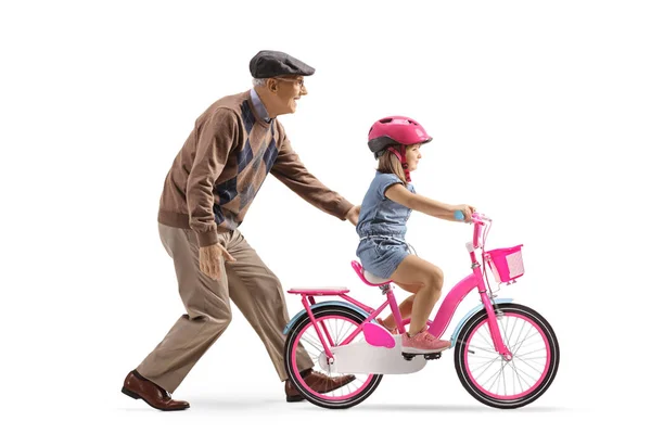 祖父は白い背景に隔離された自転車に乗る方法を少女に教えています — ストック写真