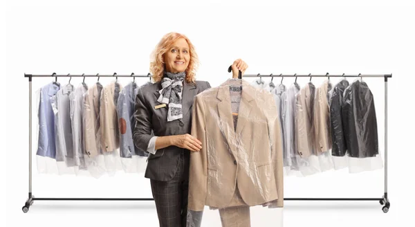 Woman holding a suit on a hanger with a case cover  in front of clothing racks isolated on a white backgroun
