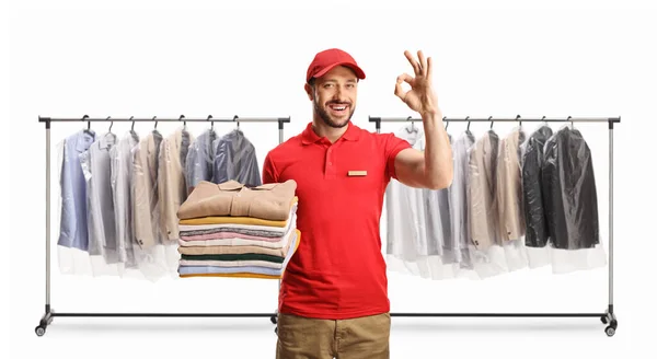 Male Worker Holding Pile Folded Clothes Gesturing Sign Front Clothing — Stock Photo, Image