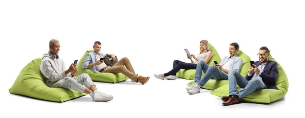Jovens Sentados Uma Poltrona Saco Feijão Usando Smartphones Isolados Fundo — Fotografia de Stock