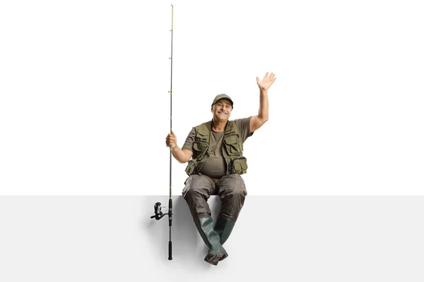 Pescador Maduro Com Uma Vara Pesca Sentado Painel Branco Acenando — Fotografia de Stock