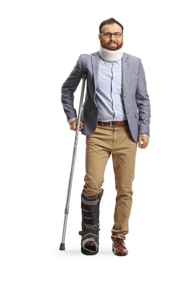 首の襟と整形外科のブーツを持つ男の完全な長さの肖像画は白の背景に隔離された松葉杖で立っている — ストック写真