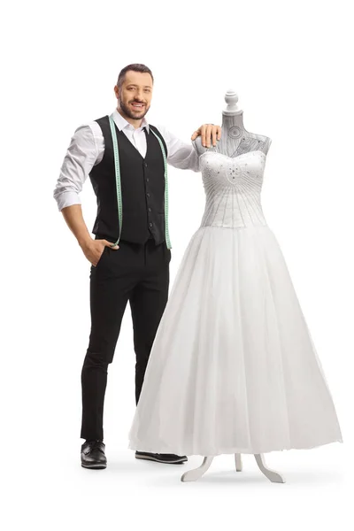 裁缝师站在白色背景的洋娃娃人偶礼服上的婚纱旁边 — 图库照片
