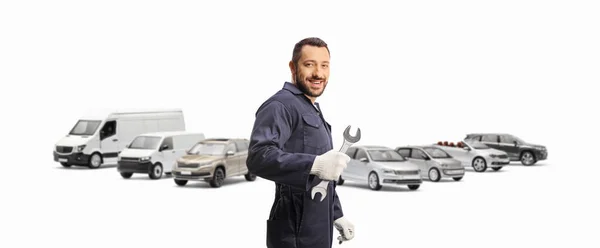 Automechaniker Mit Schraubenschlüssel Vor Geparkten Lieferwagen Und Autos Auf Weißem — Stockfoto