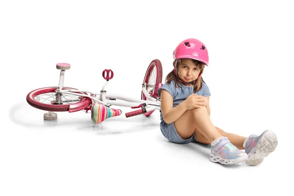 Mała Dziewczynka Nosząca Rower Trzymająca Ranne Kolano Siedząca Ziemi Odizolowana — Zdjęcie stockowe