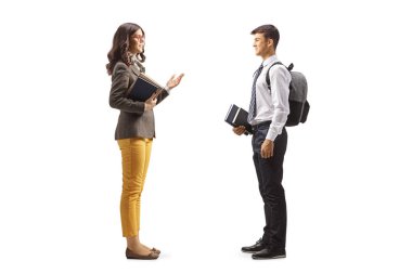 Genç bir öğretmenin beyaz arka planda izole edilmiş genç bir erkek öğrenciyle konuşurken tam boy profil fotoğrafı.