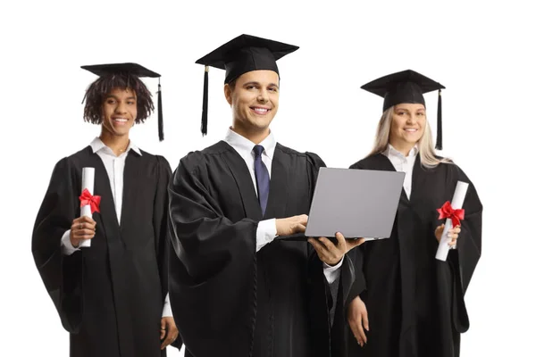 Μαθητές Στην Αποφοίτηση Φορέματα Κρατώντας Ένα Φορητό Υπολογιστή Απομονώνονται Λευκό — Φωτογραφία Αρχείου