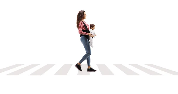 白い背景に隔離された横断歩道を歩いている運送業者の赤ん坊を持つ若い母親の完全な光のショット — ストック写真