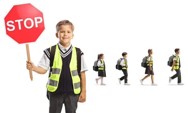 白い背景に孤立した後ろを歩く停止記号と子供を保持反射ベストを持つ学童 — ストック写真