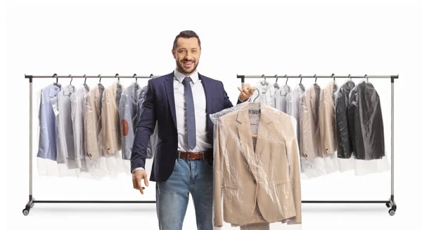 Man in front of clothing racks collecting a suit from dry cleaners isolated on a white backgroun