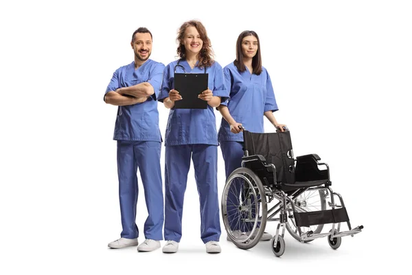 Команда Молодых Медицинских Работников Синей Форме Инвалидной Коляской Белом Фоне — стоковое фото