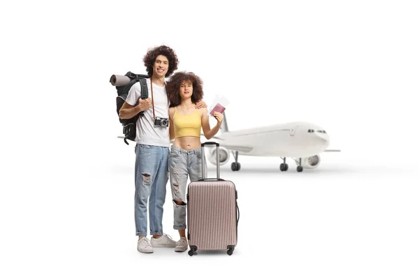 白い背景に隔離された空港でパスポートを保持しているスーツケースを持つ若いカップル — ストック写真