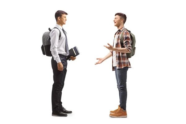 2人の男性学生の完全な長さのプロフィールショット持っていますA会話を白い背景に隔離 — ストック写真