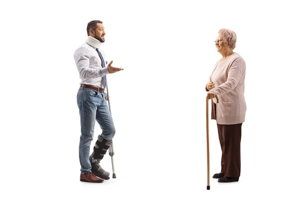 Pełna Długość Zdjęcia Rannego Mężczyzny Ortopedycznym Bucie Kołnierzyku Rozmawiającego Starszą — Zdjęcie stockowe
