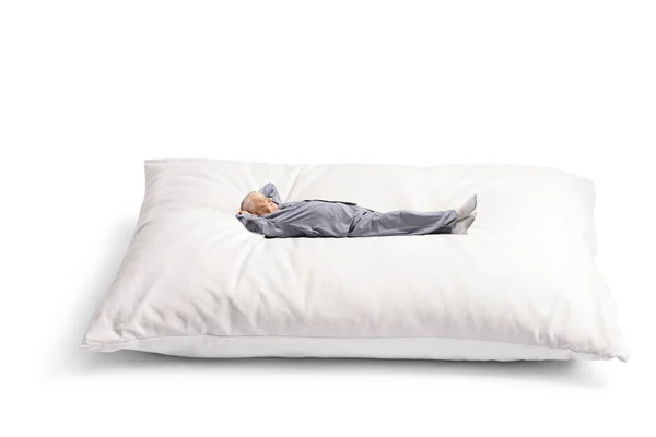 穿着睡衣的成熟男人躺在一个白色背景的大枕头上 — 图库照片