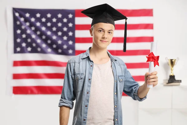 Mladý Vysokoškolský Student Držící Diplom Před Vlajkou Usa — Stock fotografie