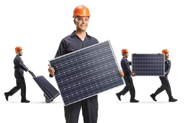 Pracownik Fabryki Mundurze Trzymający Panel Słoneczny Inni Pracownicy Niosący Panele — Zdjęcie stockowe